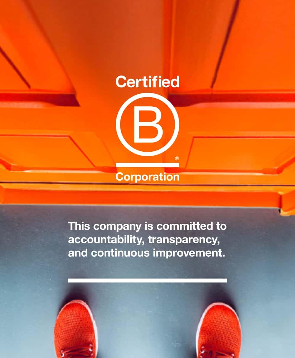 A pictue of the orange front door of B Corp design agency, Orangery, with orange trainers peaking into view